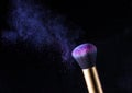 Cosmetics makeup brush and powder dust explosion. Royalty Free Stock Photo