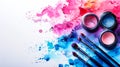 Cosmetics: makeup eyeshadows palette and brushes on a white background with vibrant blue and pink watercolor splashes. Copy space