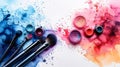Cosmetics: makeup eyeshadows palette and brushes on a white background with vibrant blue and pink watercolor splashes. Copy space