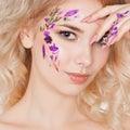 Cosmetics and manicure. Close-up portrait of attractive woman with dry flowers on her face, pastel color of nail design Royalty Free Stock Photo