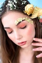 Cosmetics and manicure. Close-up portrait of attractive woman with dry flowers on her face and hair, pastel color, perfect make-up