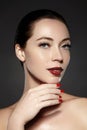 Cosmetics, manicure on nails with bright red polish. Dark red lips make-up and nail color