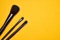 cosmetics mascara brushes decoration accessories yellow background Royalty Free Stock Photo