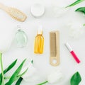 Cosmetics, perfume, hair styling tools and tulips flowers on white background. Beauty blog. Flat lay, top view Royalty Free Stock Photo