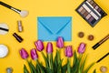 Cosmetics and pink tulips on a colour background and an envelope, spring cosmetic for women