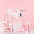 Cosmetics products for bath and spa - essential oil, bath salt, cream, liquid soap, towel in delicate pastel pink background. Royalty Free Stock Photo