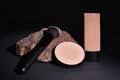 Cosmetics products with a makeup brush and compact powder lying on a granite stone Royalty Free Stock Photo