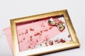 Cosmetics. Scattered shadows, applicator, balls of blush in a gold frame. Abstraction