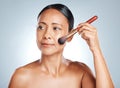 Cosmetics, senior woman and brush for dermatology, beauty and lady on grey studio background. Makeup tools, mature