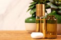 Cosmetics store wooden desk with golden liquid perfume bottle and plants Royalty Free Stock Photo