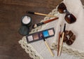 Cosmetics, sunglasses, brush on a wooden table