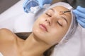 Cosmetologist applying chemical peel product on client`s face in salon