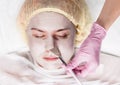 Cosmetologist applying facial mask to problem skin. young woman having skin procedures cleaning Royalty Free Stock Photo