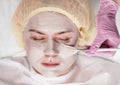 Cosmetologist applying facial mask to problem skin. young woman having skin procedures cleaning Royalty Free Stock Photo