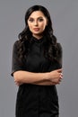 Cosmetologist in black medical uniform standing in studio