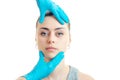 Cosmetologist in blue gloves touches the face of the young girl close-up Royalty Free Stock Photo