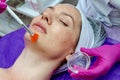 Cosmetologist doctor applies gel to the patient`s face with a brush in a beauty salon. Preparation for the procedure of