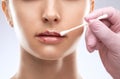 Cosmetologist does injections for lips augmentation and anti wrinkle in the nasolabial folds of a beautiful woman. Women's