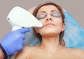 The cosmetologist does the laser hair removal procedure