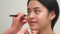 Cosmetologist draws lines under girl`s eye
