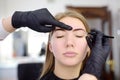 Cosmetologist eyebrow plucking. Attractive woman getting facial care and makeup at beauty salon. Architecture eyebrows Royalty Free Stock Photo