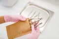 Cosmetologist in gloves holds manicure equipment