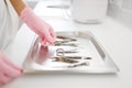 Cosmetologist in gloves holds manicure equipment