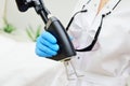 cosmetologist holds a CO2 fractional ablative laser for skin rejuvenation and scar removal in his hands and prepares for