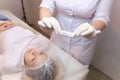 Cosmetologist holds a sterile bag with a needle in front of the client thus showing him the process of removing it from the