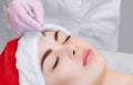 The cosmetologist makes the Botulinum toxin injection on the face skin