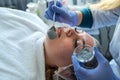 Cosmetologist makes dark mask on face young pretty woman in Spa salon