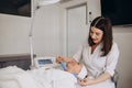 A cosmetologist makes a microcurrent facial therapy to a woman in a beauty salon.