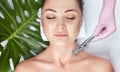 The cosmetologist makes the Microdermabrasion procedure of the facial skin of a woman in a beauty salon.Cosmetology and