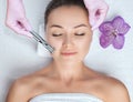 The cosmetologist makes the procedure Microdermabrasion of the face skin of a beautiful woman in a beauty salon.Cosmetology and Royalty Free Stock Photo