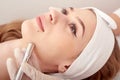 The cosmetologist makes the procedure Microdermabrasion of the facial skin of a beautiful, young woman in a beauty salon