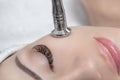 The cosmetologist makes the procedure Microdermabrasion of the facial skin of a beautiful, young woman in a beauty salon Royalty Free Stock Photo