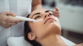 The cosmetologist makes the procedure Microdermabrasion of the facial skin of a beautiful, young woman in a beauty salon.