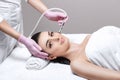 The cosmetologist makes the procedure Microdermabrasion of the facial skin of a beautiful, young woman in a beauty salon