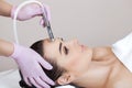The cosmetologist makes the procedure Microdermabrasion of the facial skin of a beautiful, young woman in a beauty salon Royalty Free Stock Photo