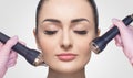 The cosmetologist makes the procedure an ultrasonic cleaning of the facial skin of a beautiful, young woman in a beauty salon Royalty Free Stock Photo