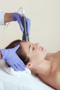 The cosmetologist makes the procedure an ultrasonic cleaning of the facial skin of a beautiful, young woman in a beauty salon. Royalty Free Stock Photo