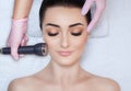 The cosmetologist makes the procedure an ultrasonic cleaning of the facial skin of a beautiful, young woman in a beauty salon Royalty Free Stock Photo