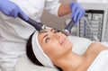 The cosmetologist makes the procedure an ultrasonic cleaning of the facial skin of a beautiful, young woman in a beauty salon. Royalty Free Stock Photo