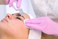 Cosmetologist makes ultrasonic face cleaning procedure to young woman in clinic. Royalty Free Stock Photo