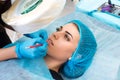 Cosmetologist making permanent makeup on woman`s face Royalty Free Stock Photo