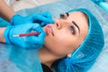 Cosmetologist making permanent makeup on woman`s face Royalty Free Stock Photo