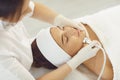 Cosmetologist making procedure of microdermabrasion of facial skin for woman