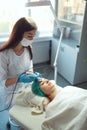 The cosmetologist performs a cosmetic procedure with ultrasound phonophoresis.