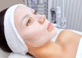 The cosmetologist for procedure of cleansing and moisturizing the skin, applying a sheet mask to the face