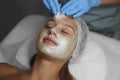 Cosmetologist removing mask from client`s face in spa salon